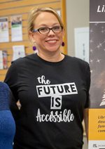[Image description: Amber Fawn Wooton Clark smiles while wearing a black and white T shirt that reads “The Future is Accessible.]
